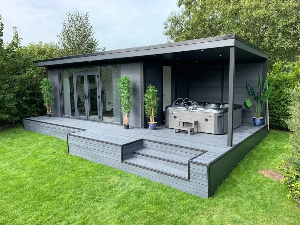 Dark grey garden room with bi-fold doors and covered decking