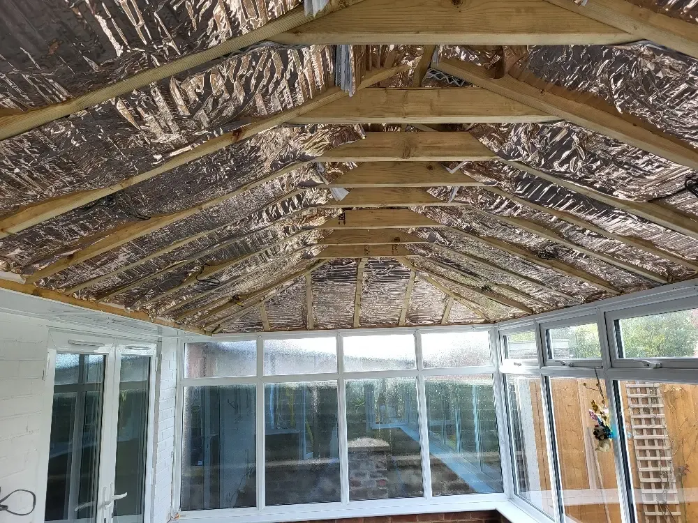 Insulated ceiling being installed inside a conservatory roof
